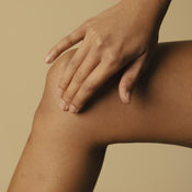 A woman applying Baalm to her knee.