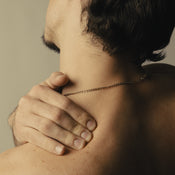 A man clutching his left should with his right hand.